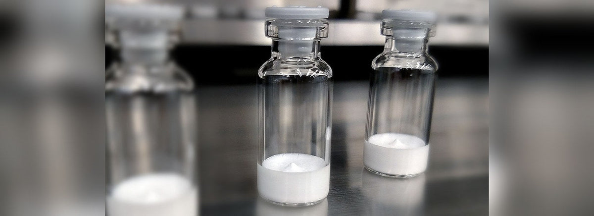 Glass vials of freeze-dried peptide powder on a laboratory bench