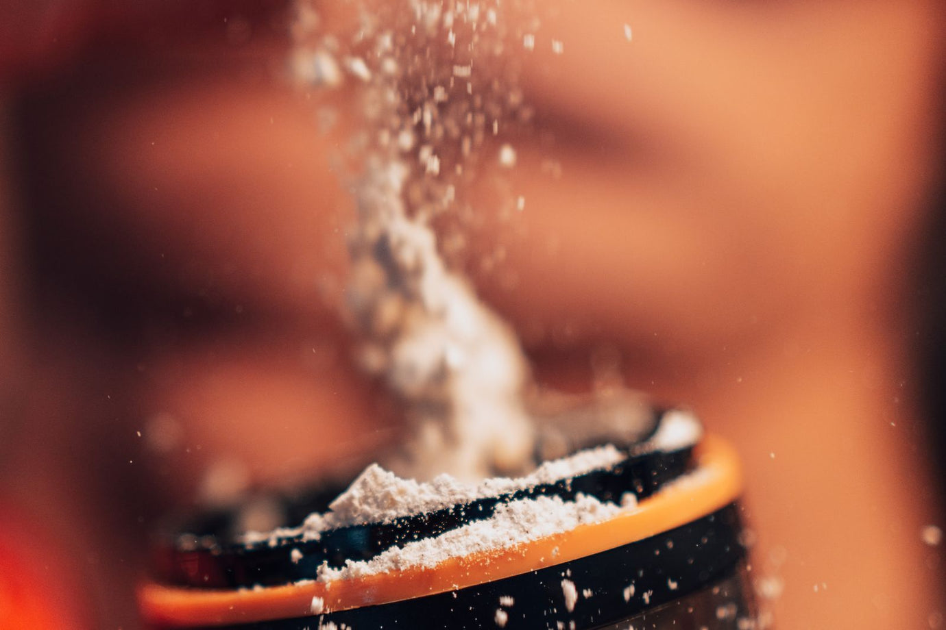 Scoop of creatine powder being added to a shaker - creatine loading phase guide