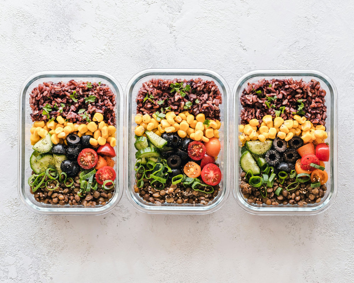 Glass meal prep containers with rice, lentils and vegetables, illustrating balanced meals to lose weight safely
